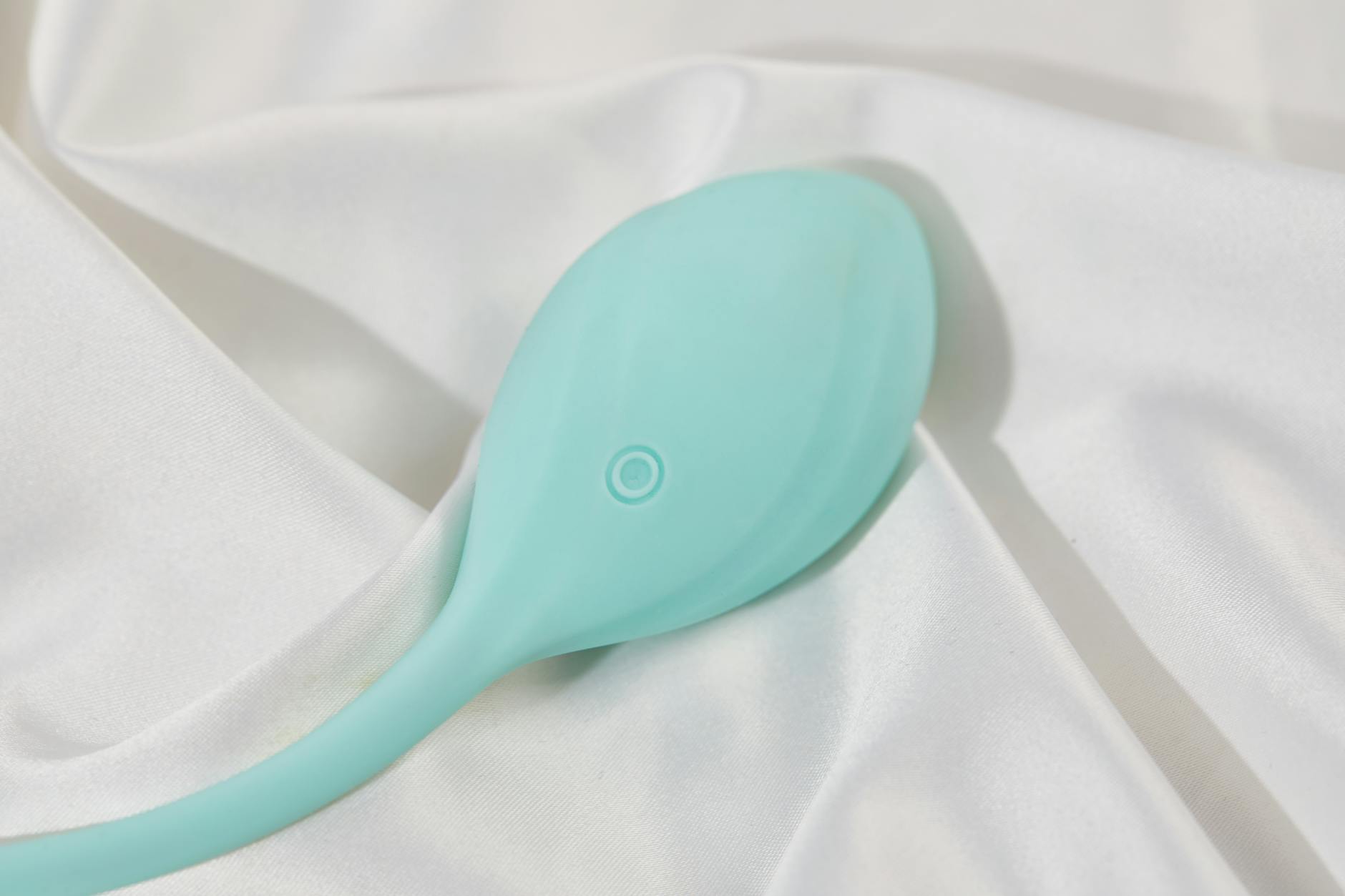 Ein stilvoller Lemon-Vibrator auf glatter Seide, Symbol für langfristige Lust und bewusste Selbstentdeckung
